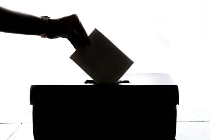 Silhouette of a hand placing a vote for elections.
