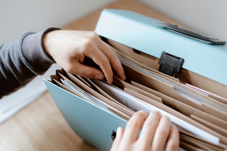 Person choosing document in folder about How to File a Patent in India?