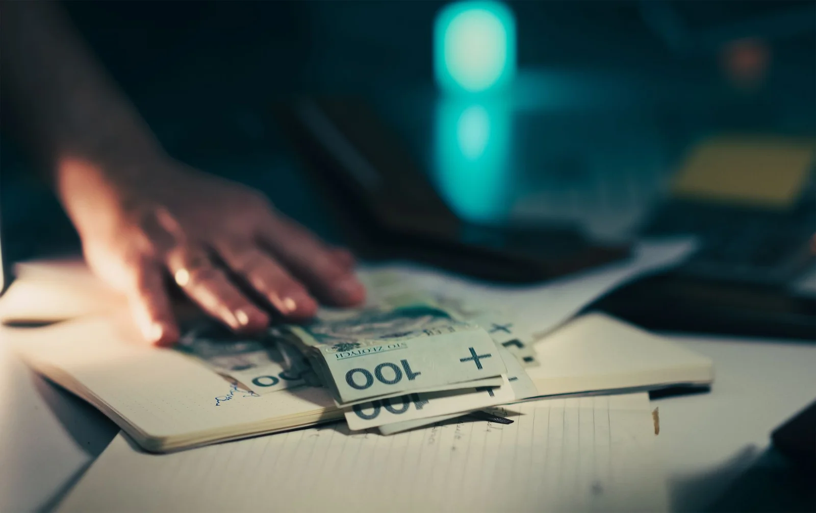 Cross-Border ESOPs in India: Legal, Tax - Close-up of hand reaching for banknotes on an office desk with a notebook and calcu