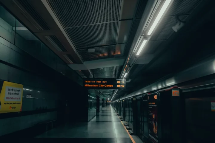 Data Centre SEZ Framework under the - A dimly lit urban subway platform in New Delhi with signs in multiple languages.
