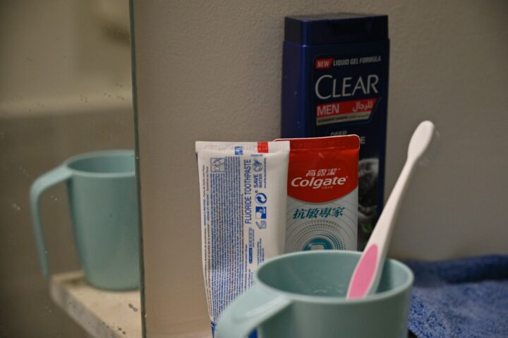 Toothbrush, toothpaste, and shampoo on bathroom counter.