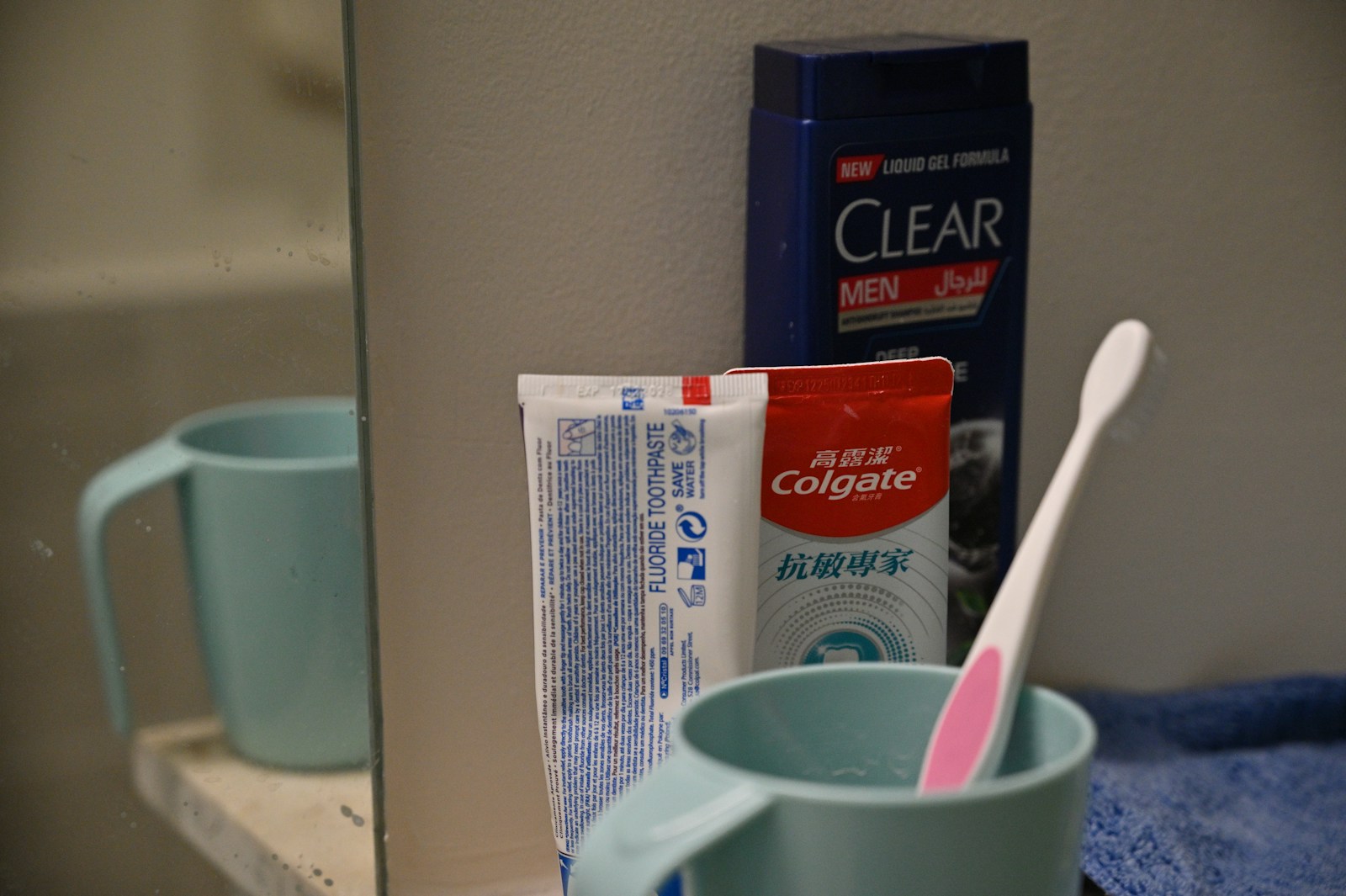 Toothbrush, toothpaste, and shampoo on bathroom counter.