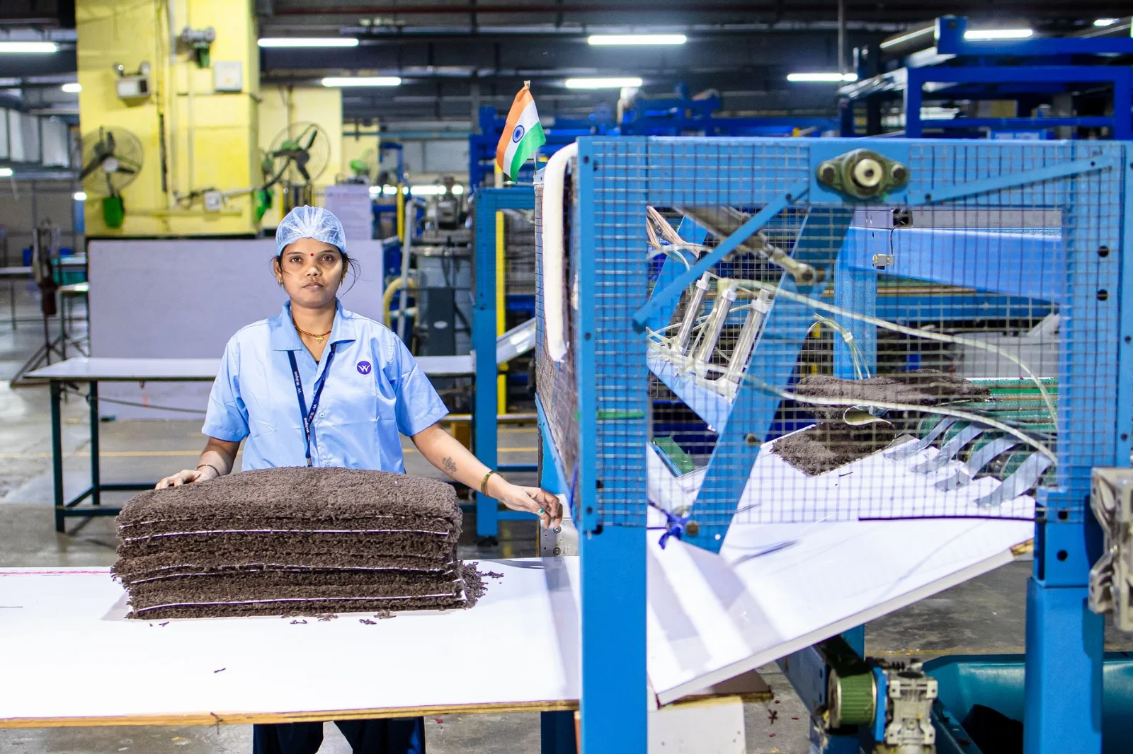 Made in India, Powered by China: - An Indian factory worker operates machinery in a textile manufacturing facility, demonstra