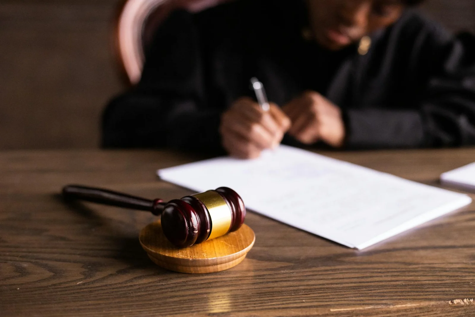 Non-Parties and Contempt: Expanding the Boundaries - Judge signing documents at desk with focus on gavel, representing law an