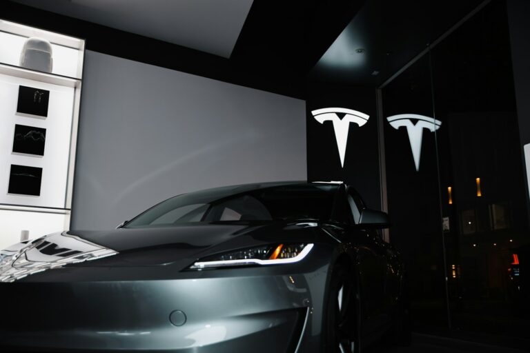 A car parked in front of a large screen - Tesla’s arrival in India