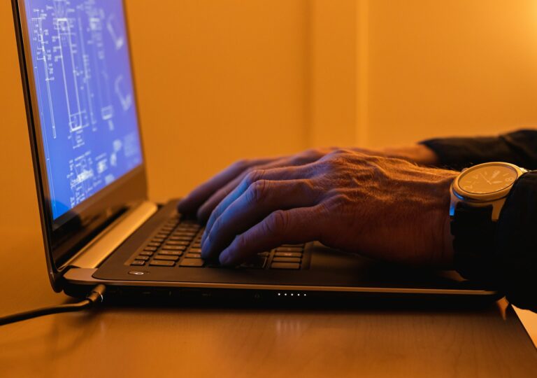 a person using a laptop computer on a desk - Technology in NDPS Investigations
