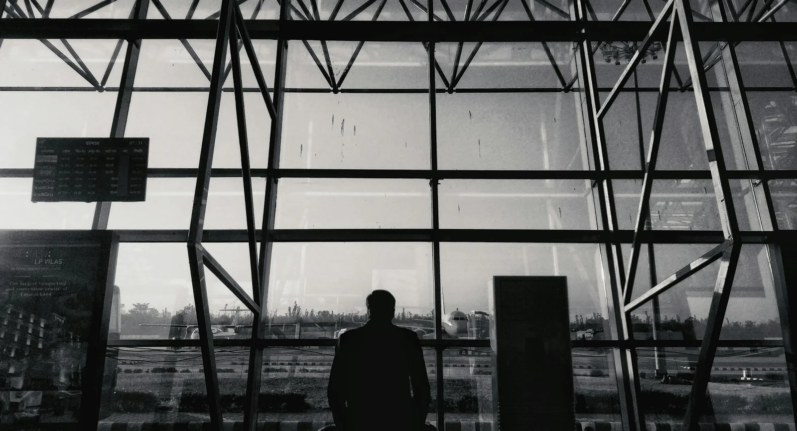 airport infrastructure project finance india - - Silhouette of a man looking through glass windows at an airport terminal in