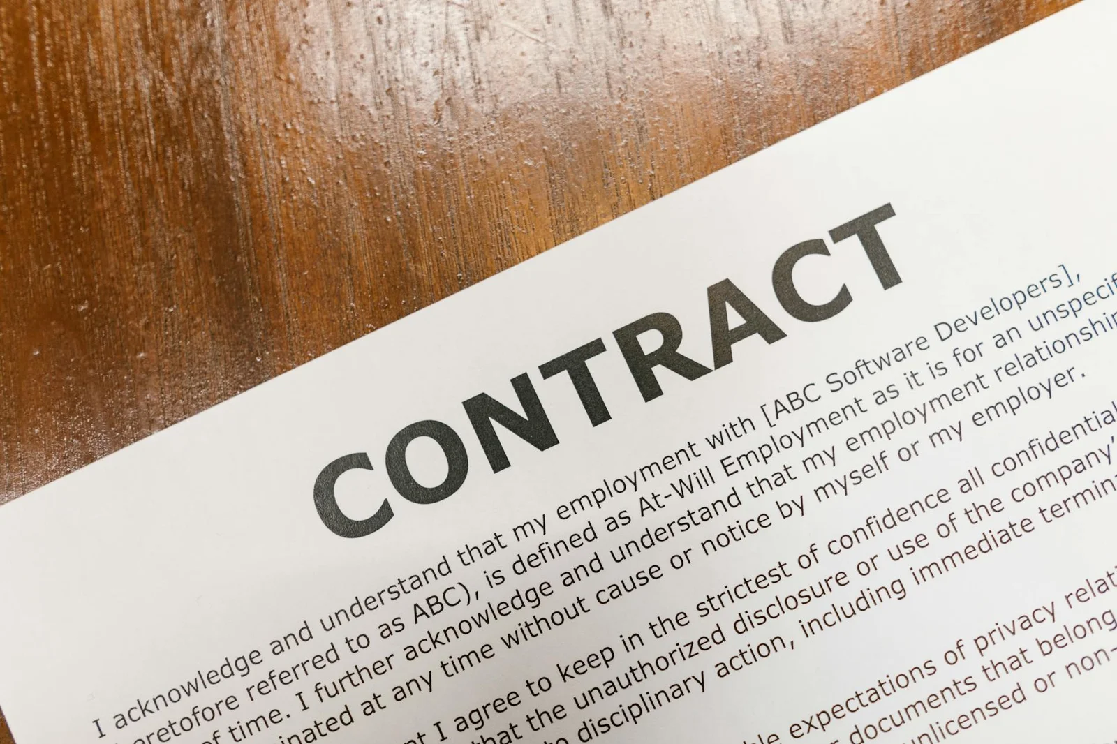 change in law power purchase agreements - A detailed close-up of a printed contract document on a wooden table surface.