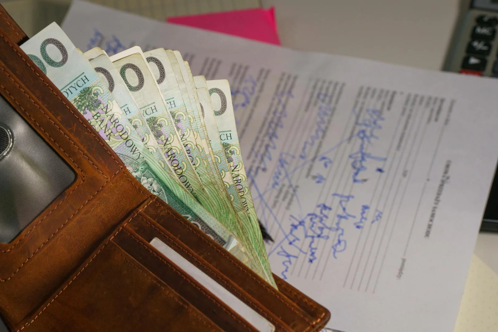 section 133 indian contract act surety - Close-up of a wallet containing Polish Zloty with a signed document in the backgroun