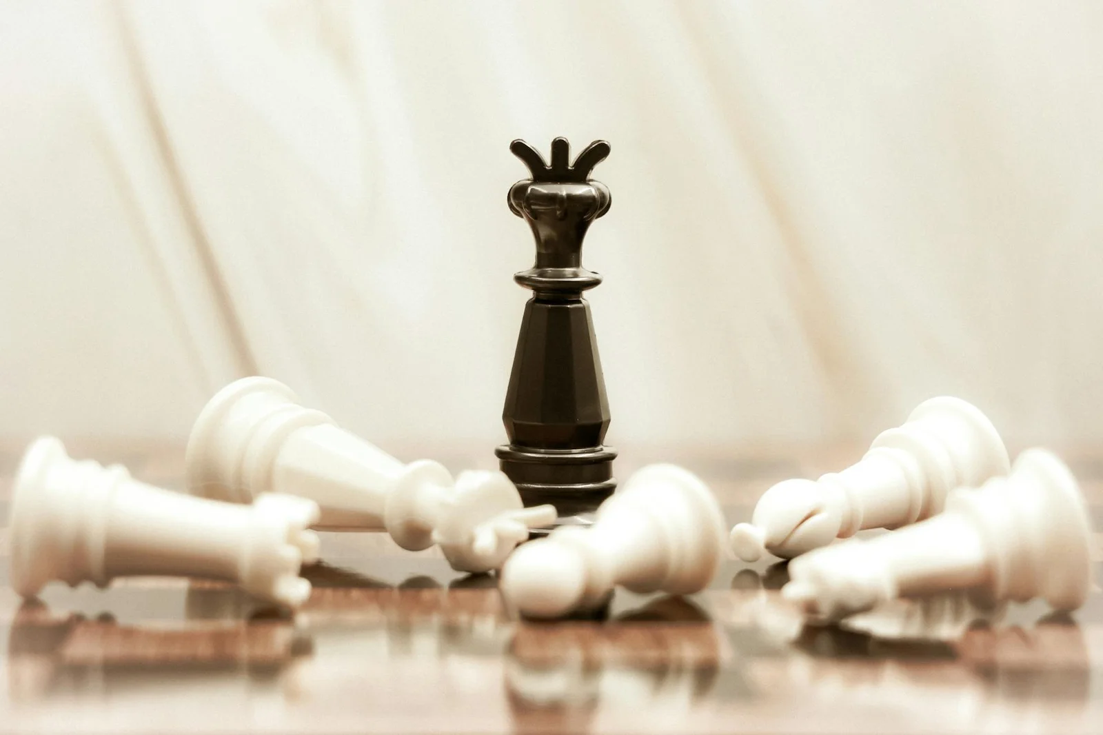 abuse of dominant position competition act - A black chess queen stands triumphant among toppled white pieces on a reflective