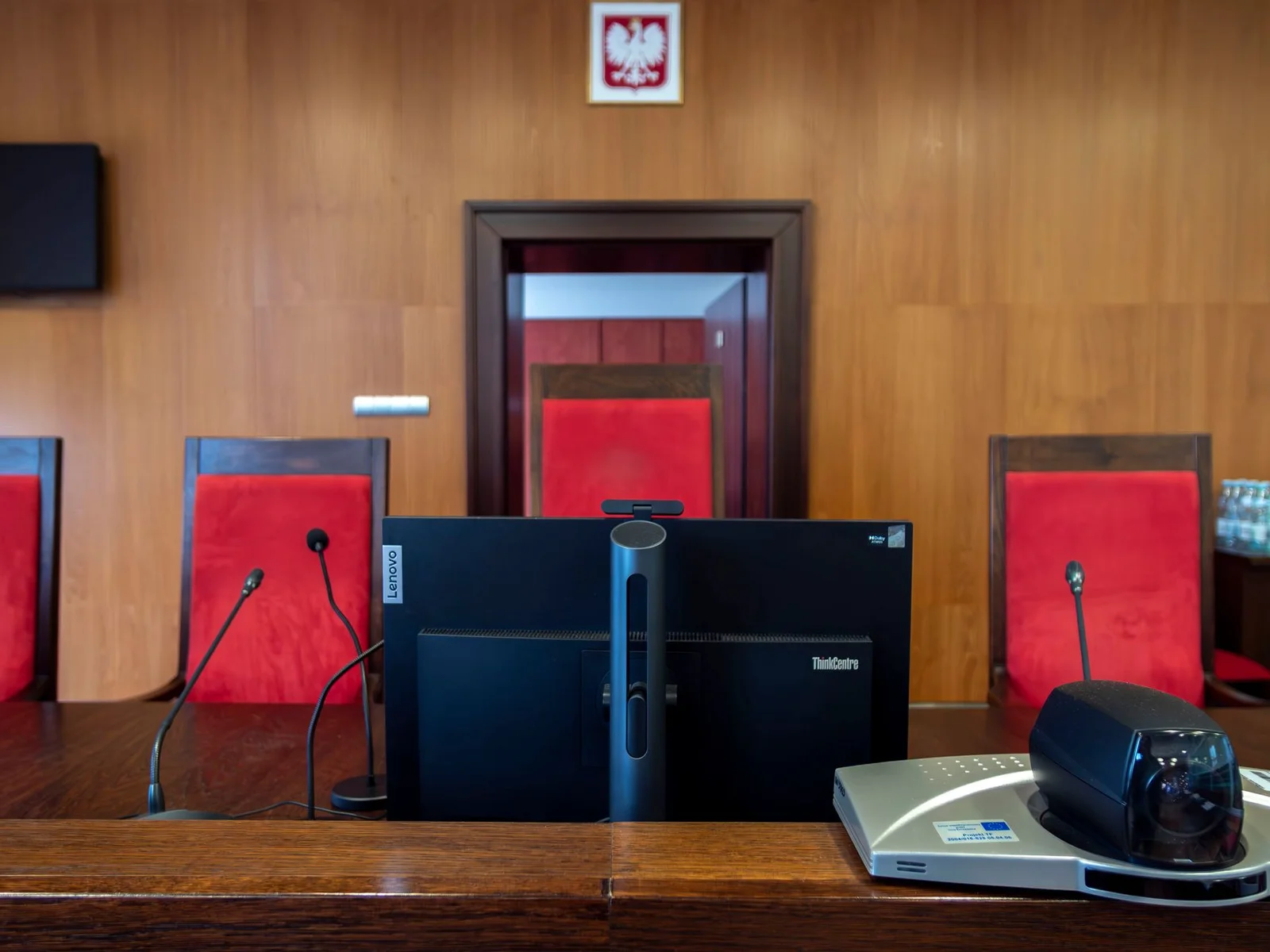 sarfaesi ibc moratorium - SARFAESI v. - Modern courtroom interior in Wrocław, Poland featuring judge's bench and red seating.