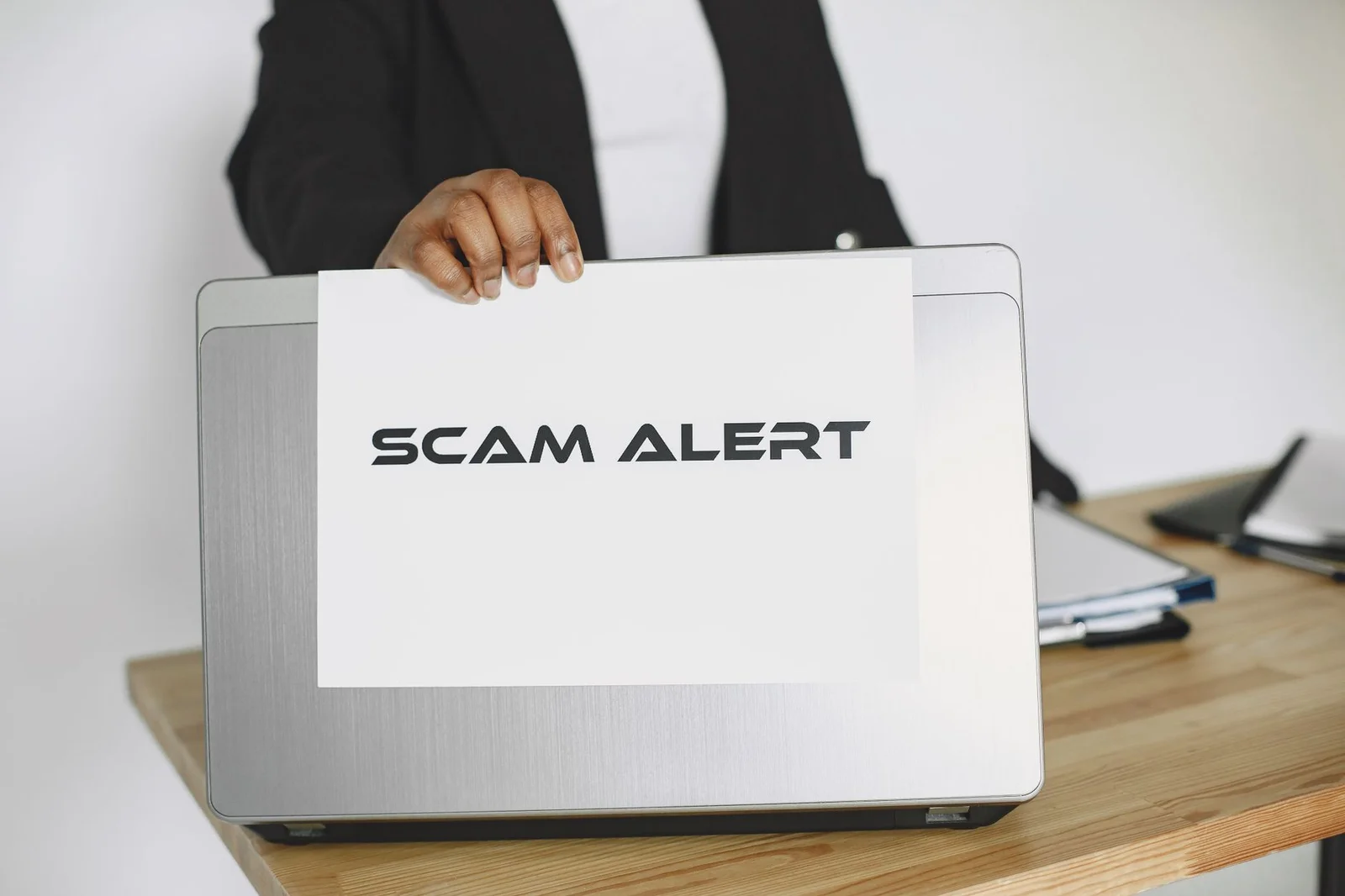 sebi pfutp regulations fraud disgorgement - - Business person holding a scam alert sign over a laptop, warning against online