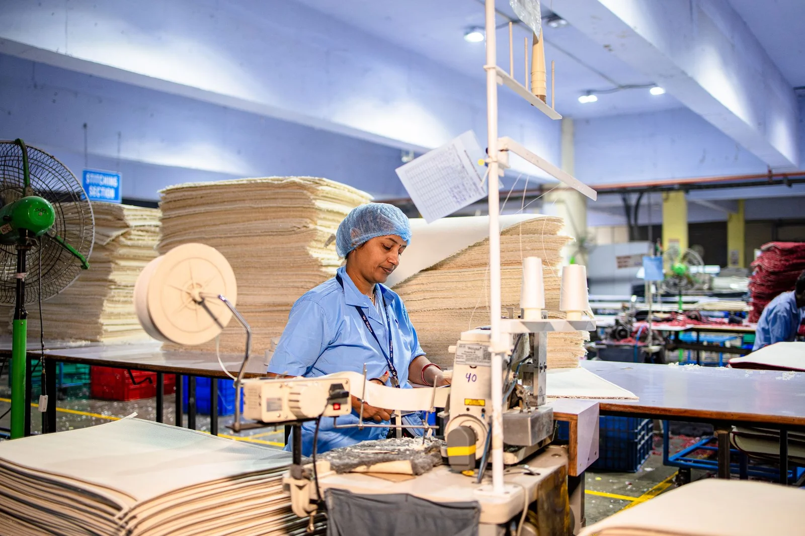 employee secondment taxation india - Employee - A female worker sewing in a textile factory, showcasing industrial production