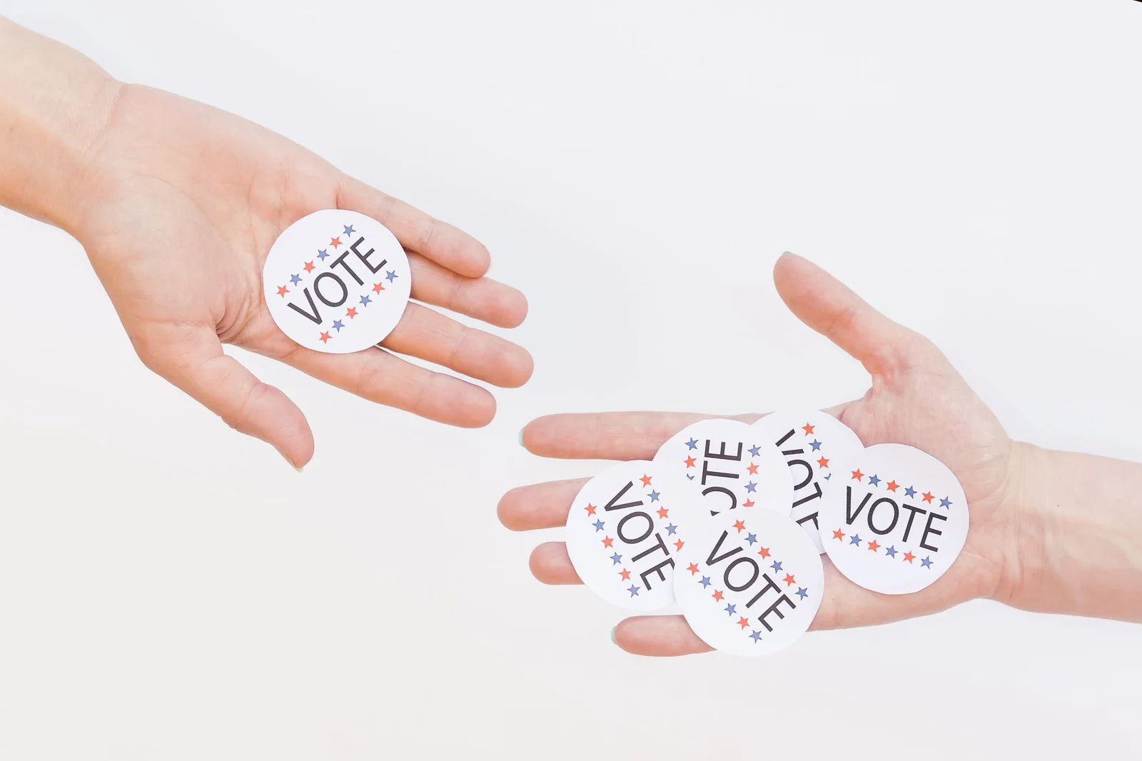 cooperative societies instrumentality state - Autonomy - Close-up of hands holding election vote stickers, symbolizing partic