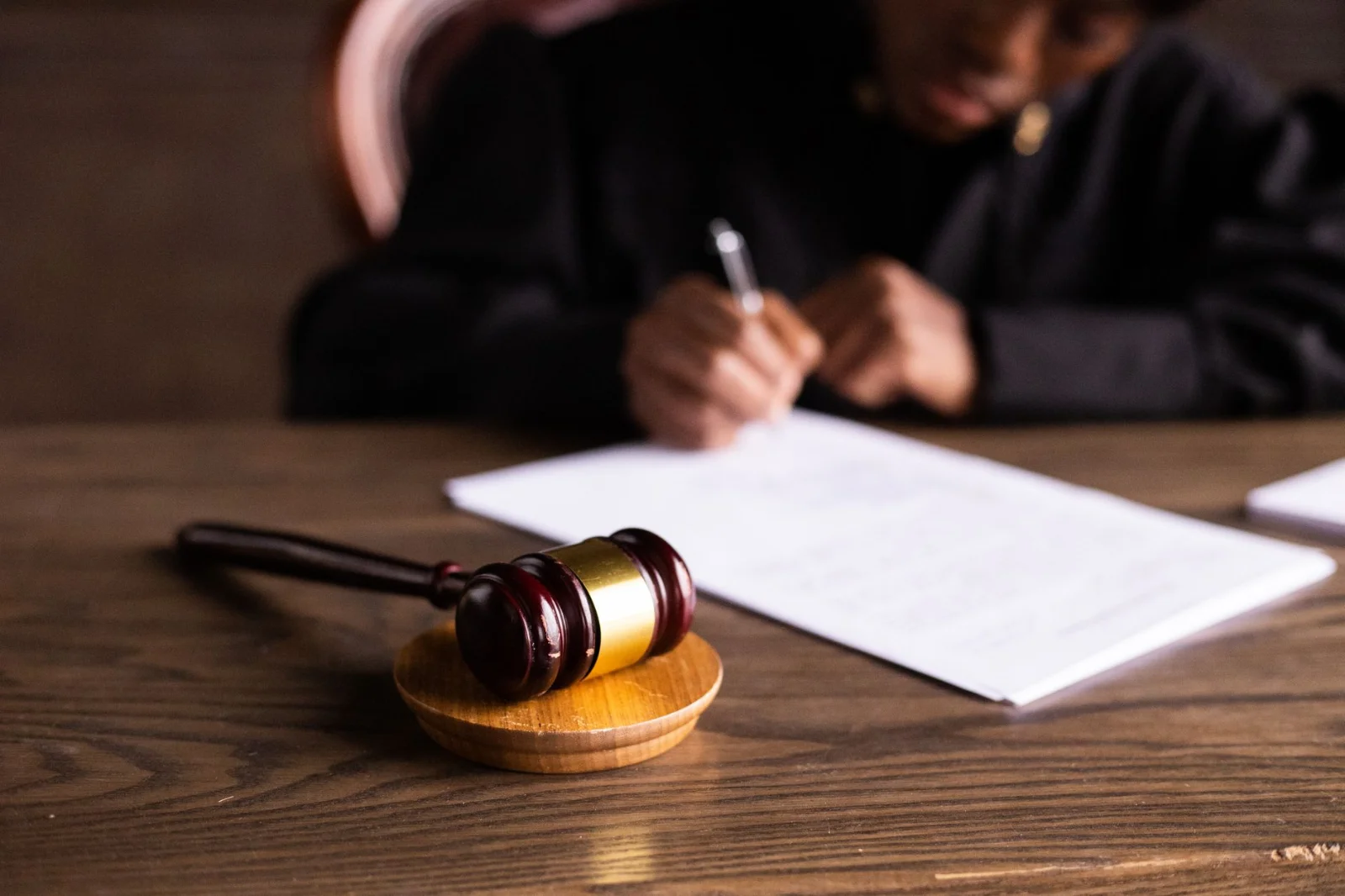 Supreme Court Clarifies That an Appointment - Judge signing documents at desk with focus on gavel, representing law and justi
