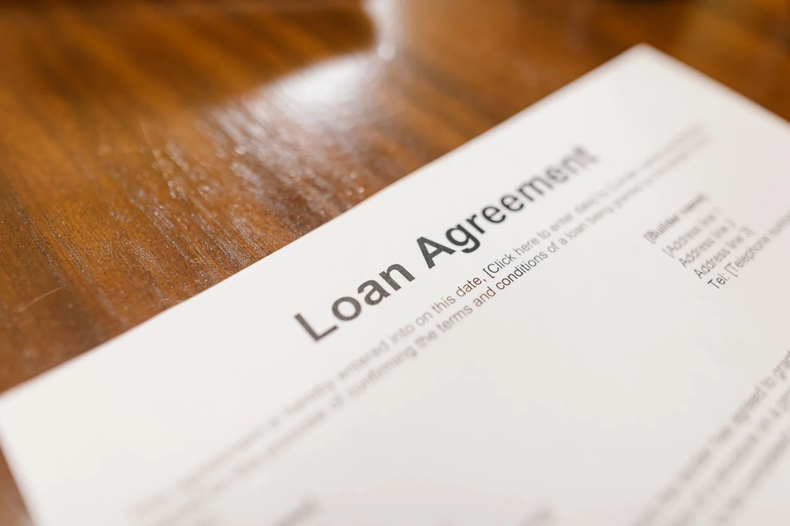 Surety Discharged Where Loan Terms Altered - Detailed loan agreement document close-up on a wooden table representing legal a