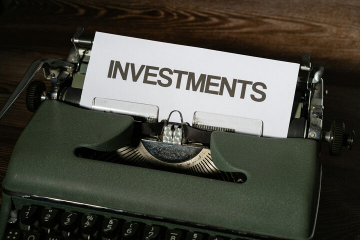 a close up of a typewriter with a paper that reads investments - AIF investments