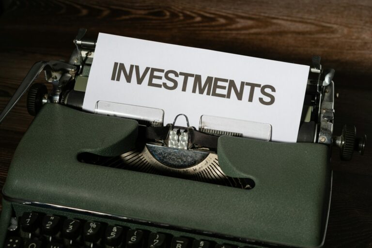 a close up of a typewriter with a paper that reads investments - AIF investments